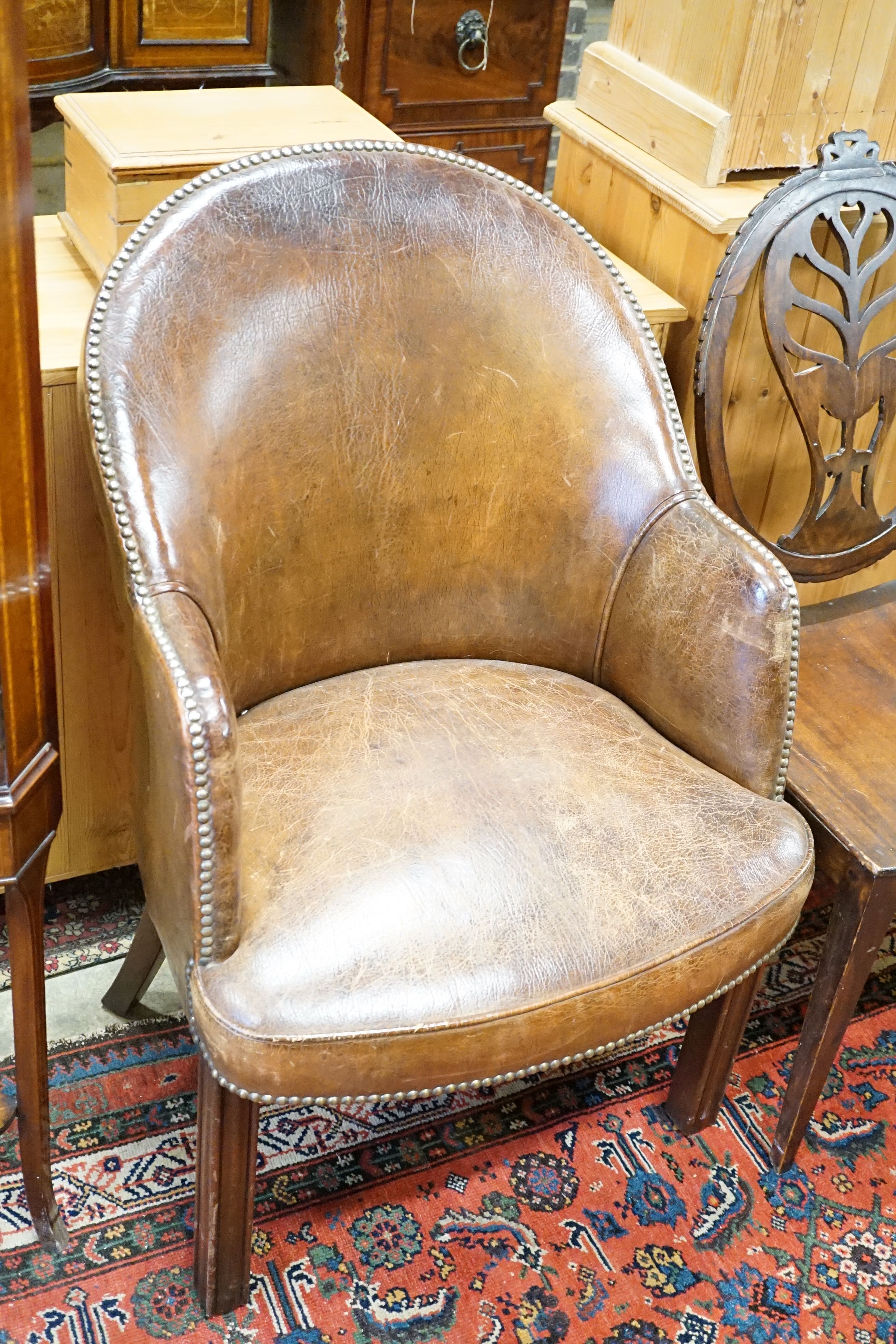 A brown leather upholstered desk chair, a mahogany hall chair and two upholstered armchairs